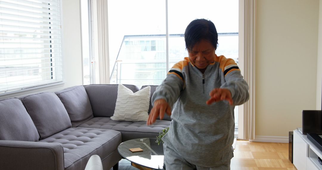 Senior Woman Practicing Tai Chi in Modern Living Room - Free Images, Stock Photos and Pictures on Pikwizard.com