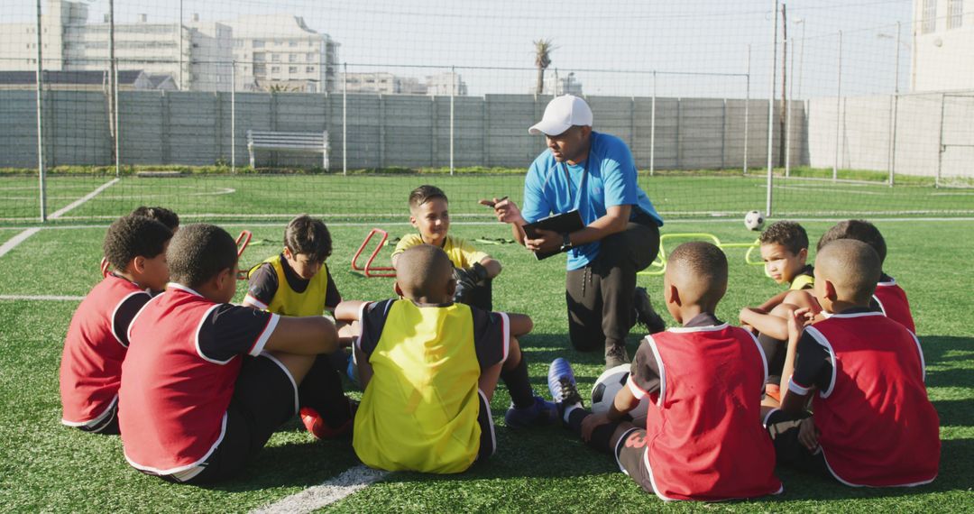 Youth Soccer Team Sitting on Field Listening to Coach - Free Images, Stock Photos and Pictures on Pikwizard.com