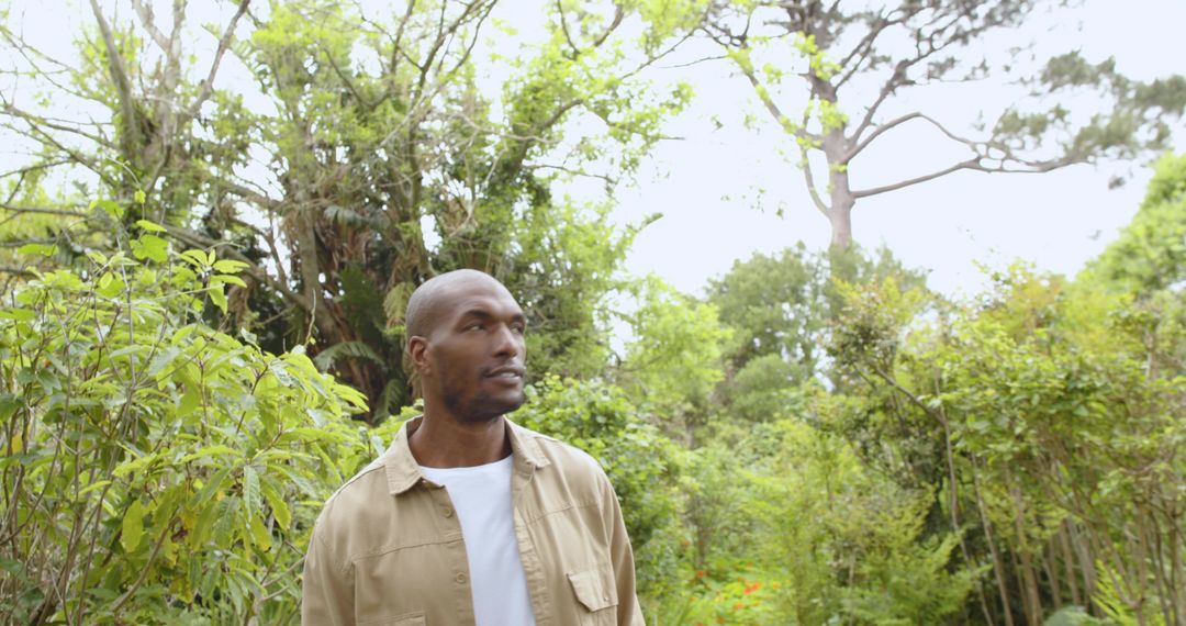 Man Embracing Nature Among Lush Greenery in Tranquil Garden