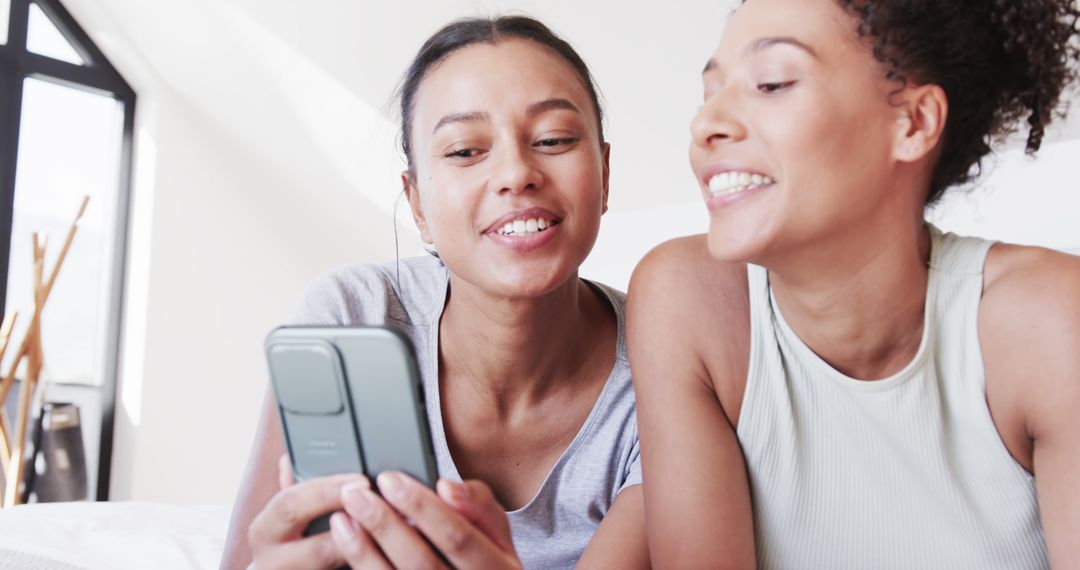 Smiling Multiracial Women Enjoying Shared Smartphone Moment - Free Images, Stock Photos and Pictures on Pikwizard.com