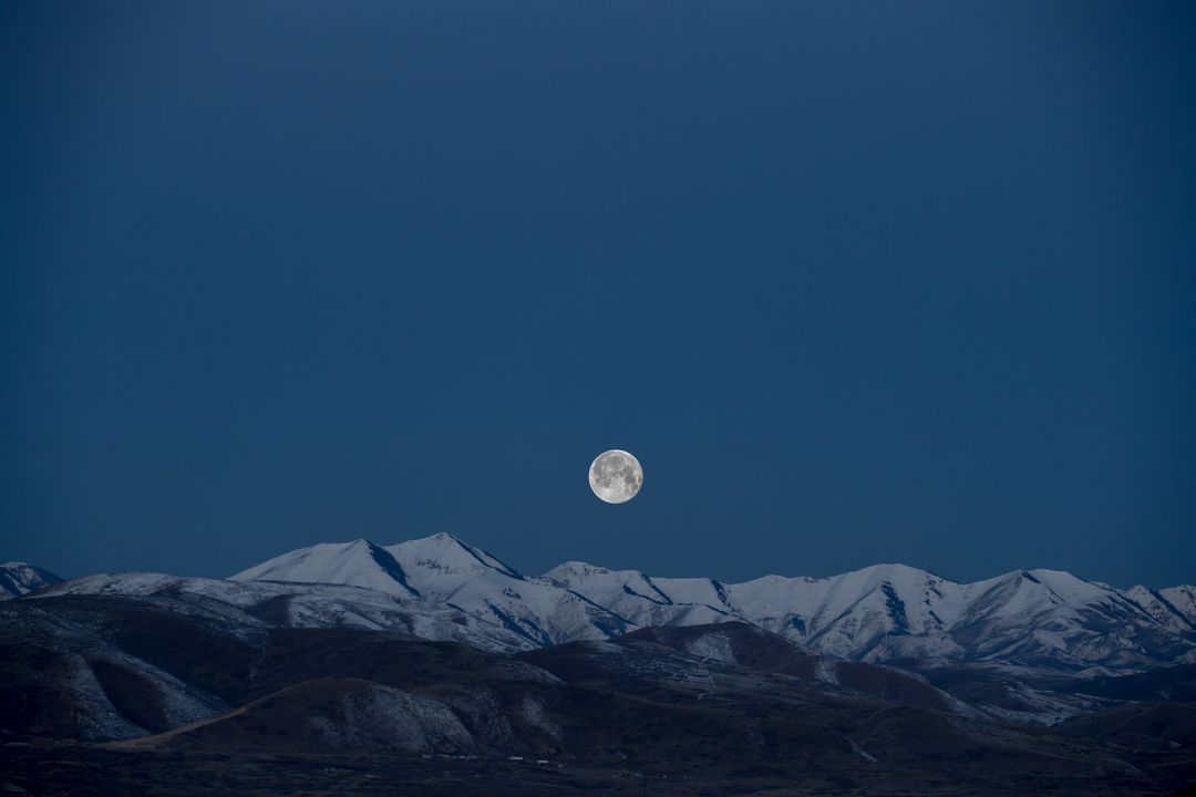 Full Moon Over Snow-Capped Mountain Range at Dusk