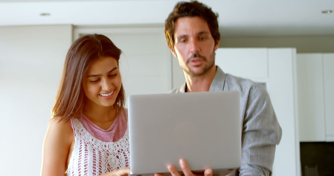 Mixed Ethnicity Couple Collaboratively Working on Laptop