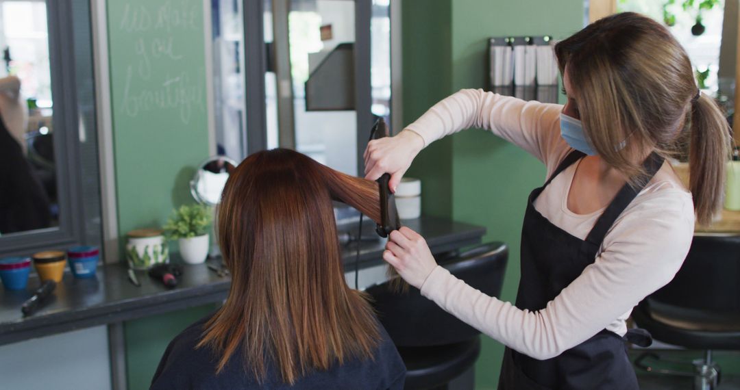 Hairdresser Styling Client's Hair with Curling Iron in Salon - Free Images, Stock Photos and Pictures on Pikwizard.com