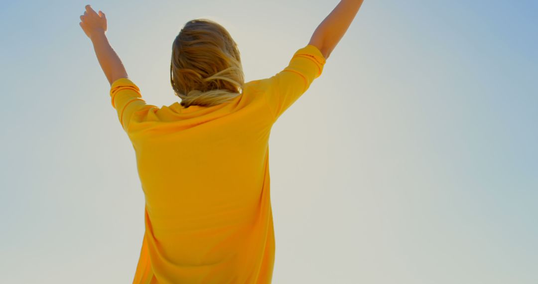 Woman Celebrating with Arms Raised Against Clear Blue Sky - Free Images, Stock Photos and Pictures on Pikwizard.com