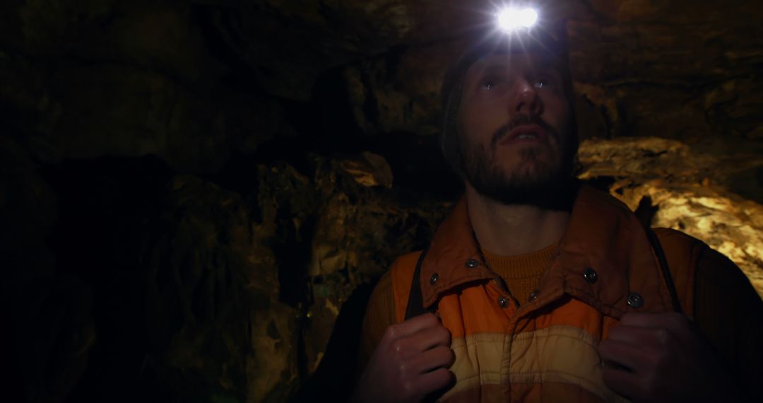 Man Wearing Headlamp Explores Dark Natural Cave