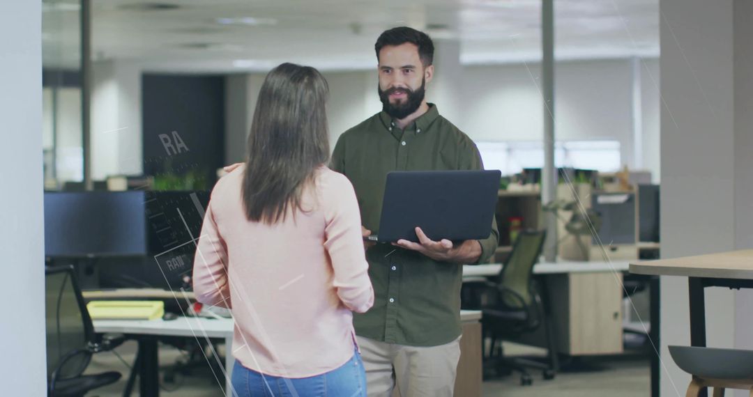 Two Coworkers Discussing Projects in Modern Office Workspace