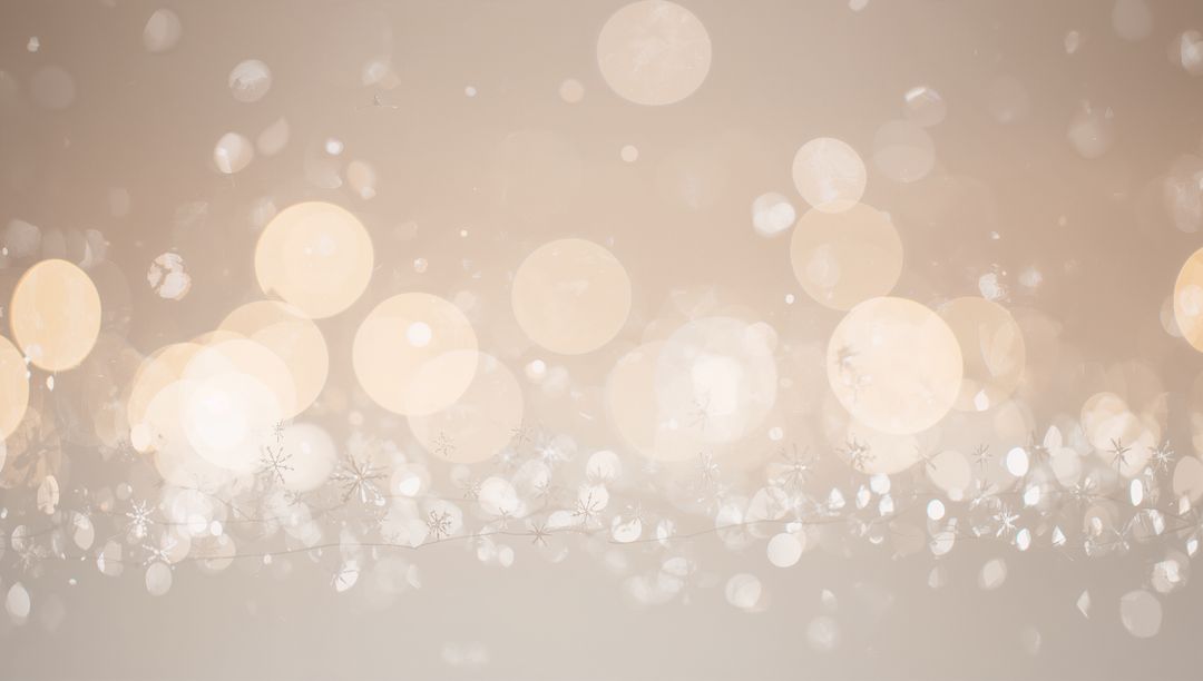 Glowing warm beige bokeh with snowflake garland creating festive ethereal backdrop