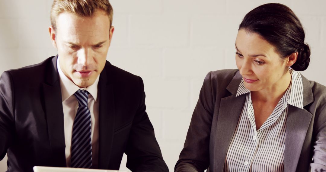 Caucasian Business Professionals Analyzing Data on Tablet