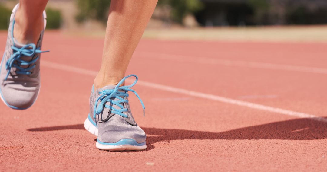 Athlete Running on Track in Gray Sneakers with Blue Laces - Free Images, Stock Photos and Pictures on Pikwizard.com