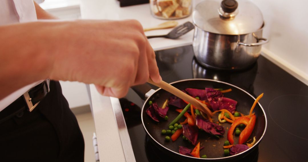 Person Cooking Colorful Vegetables on Stove in Kitchen - Free Images, Stock Photos and Pictures on Pikwizard.com