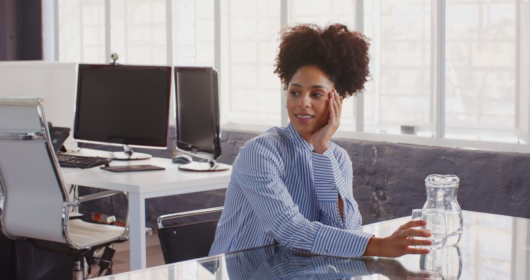 Thoughtful Businesswoman Sipping Water at Modern Office Desk