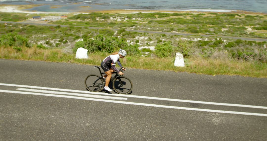 Cyclist Riding Bike on Scenic Coastal Road - Free Images, Stock Photos and Pictures on Pikwizard.com