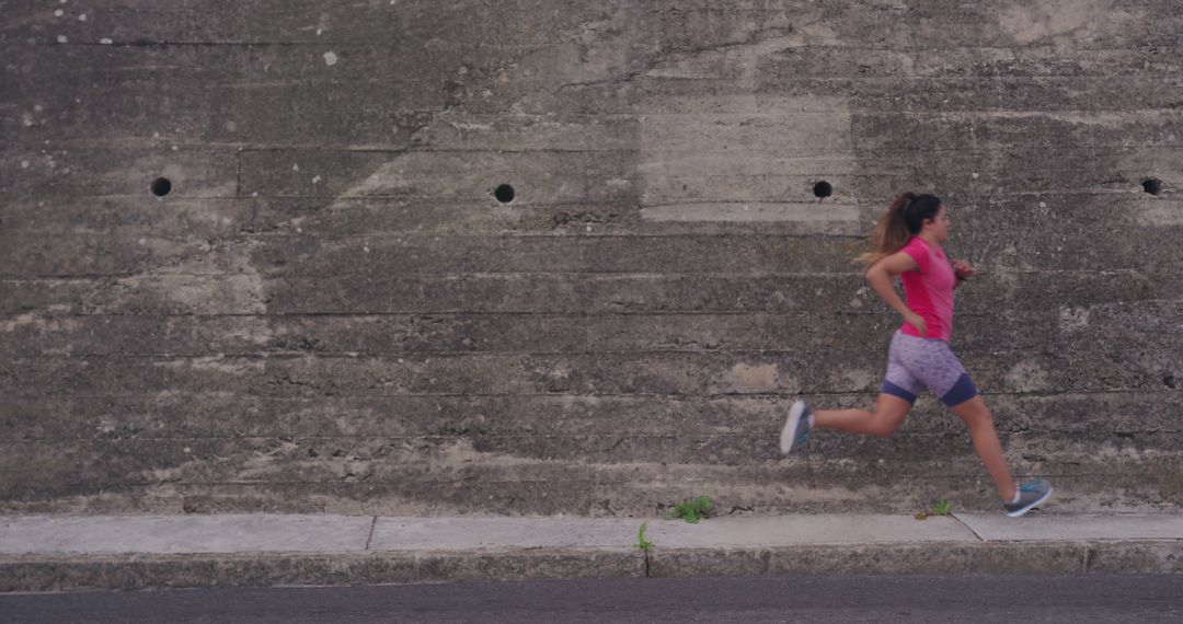 Female Athlete Running by Concrete Wall for Outdoor Workout - Free Images, Stock Photos and Pictures on Pikwizard.com