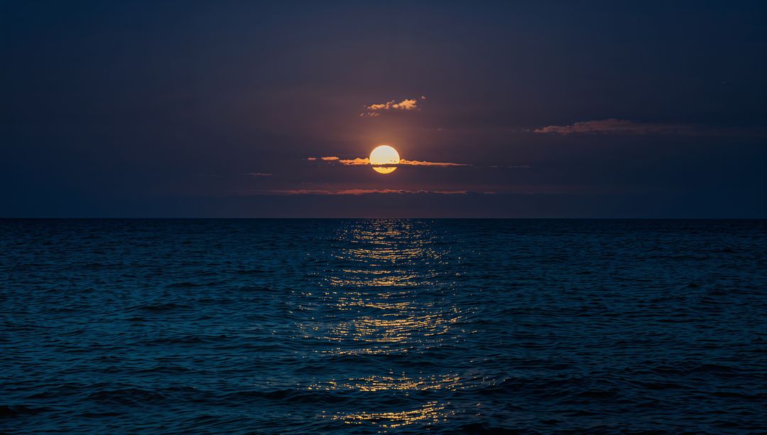 Moonlit Ocean Reflection Creating Golden Path Across Calm Sea at Twilight Horizon