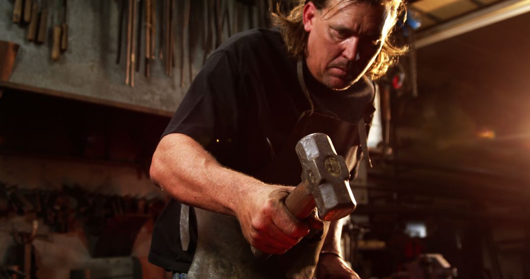 Dedicated Blacksmith Forging Iron in Workshop