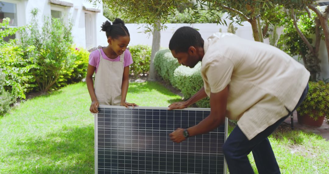 Father and Daughter Installing Solar Panel in Solar-Powered Garden