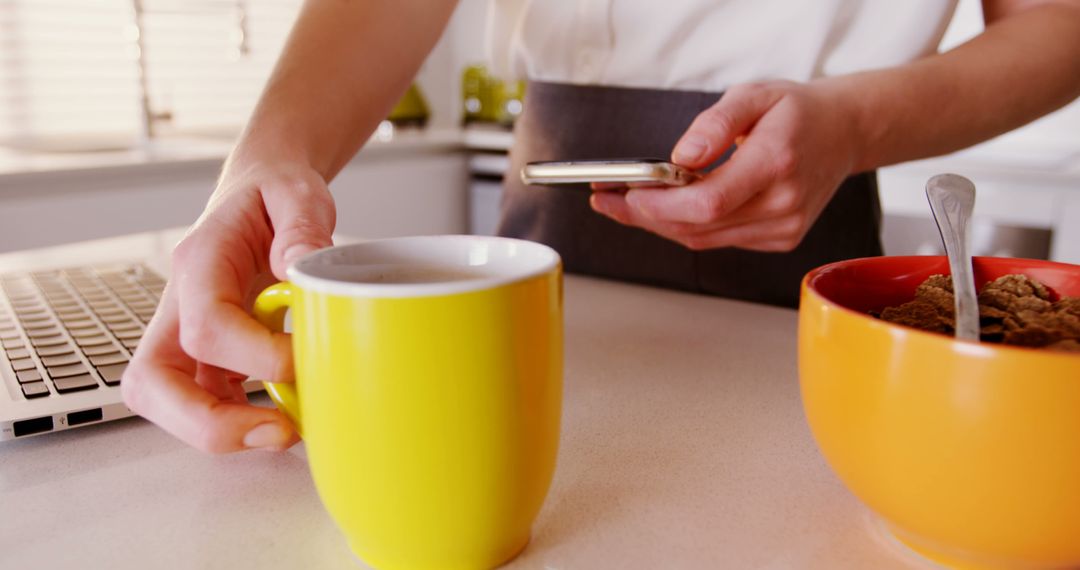 Person Having Breakfast Using Smartphone in Kitchen - Free Images, Stock Photos and Pictures on Pikwizard.com