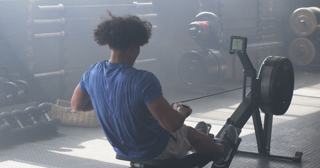 Man Using Rowing Machine in Gym for Intense Workout