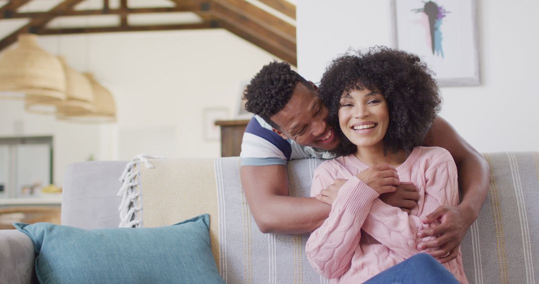 Happy african american couple embracing together in living room - Free Images, Stock Photos and Pictures on Pikwizard.com