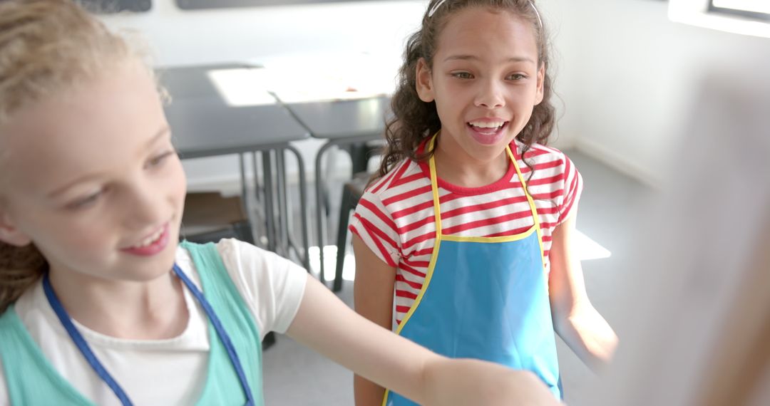 Two Girls Painting in Classroom Collaborating on Art Project