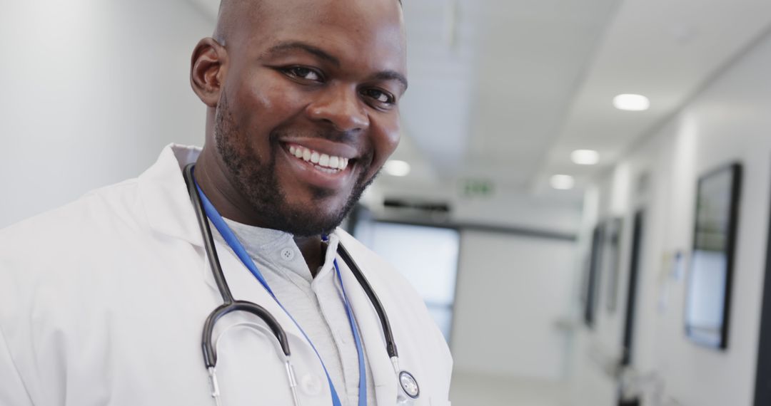 Confident African American Doctor Smiling in Hospital Corridor with Stethoscope - Free Images, Stock Photos and Pictures on Pikwizard.com