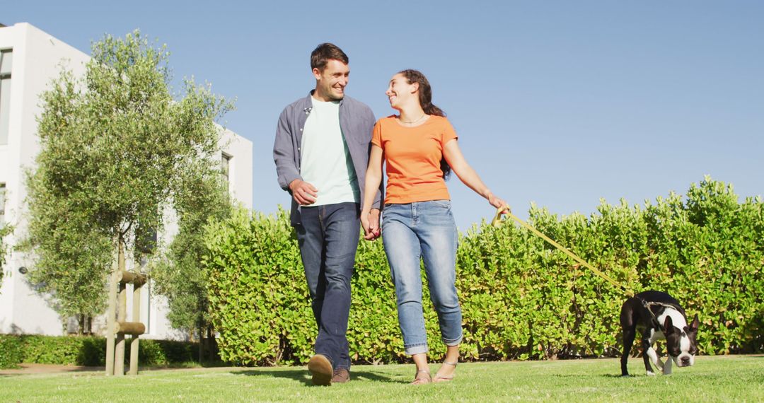 Happy Couple Strolling in Sunlit Park with Stylish Puppy