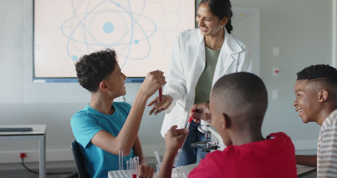 Teacher Guiding Students in Science Lab with Atomic Screen