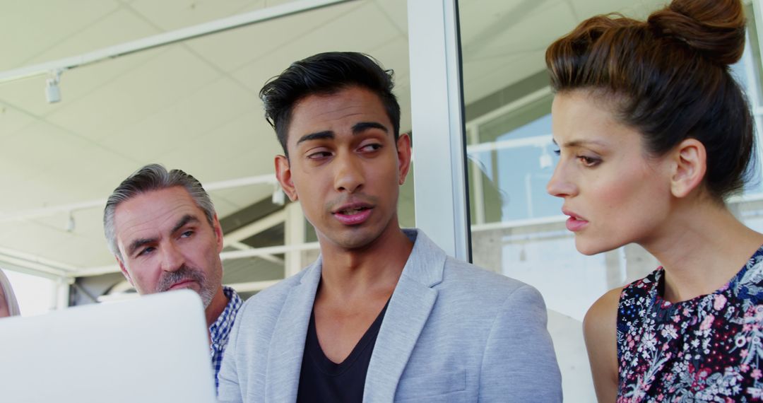 Diverse Team in Critical Discussion Analyzing Laptop