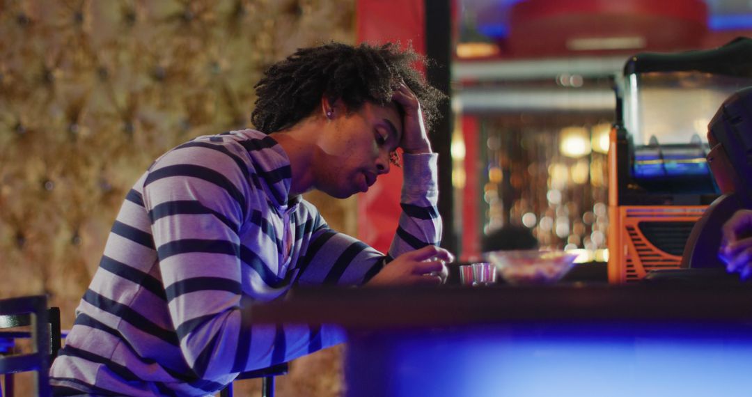 Stressed Man at Bar with Drink in Hand