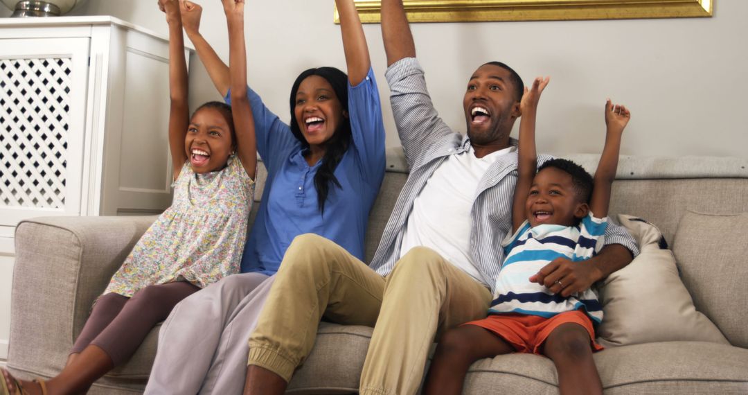 Happy Family Watching TV and Cheering Enthusiastically