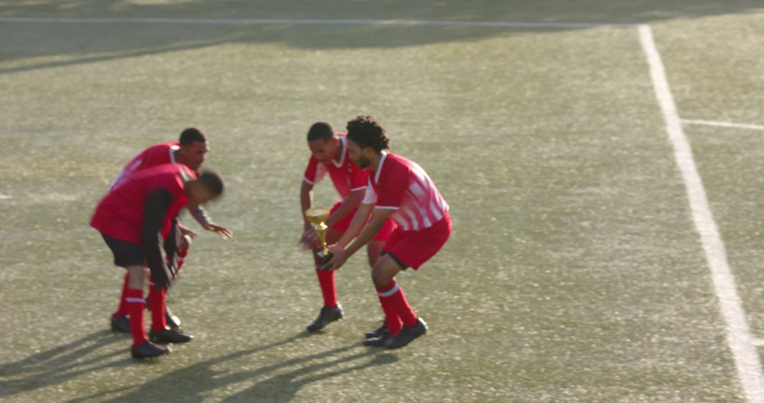Soccer Team Celebrating Victory With Trophy on Field