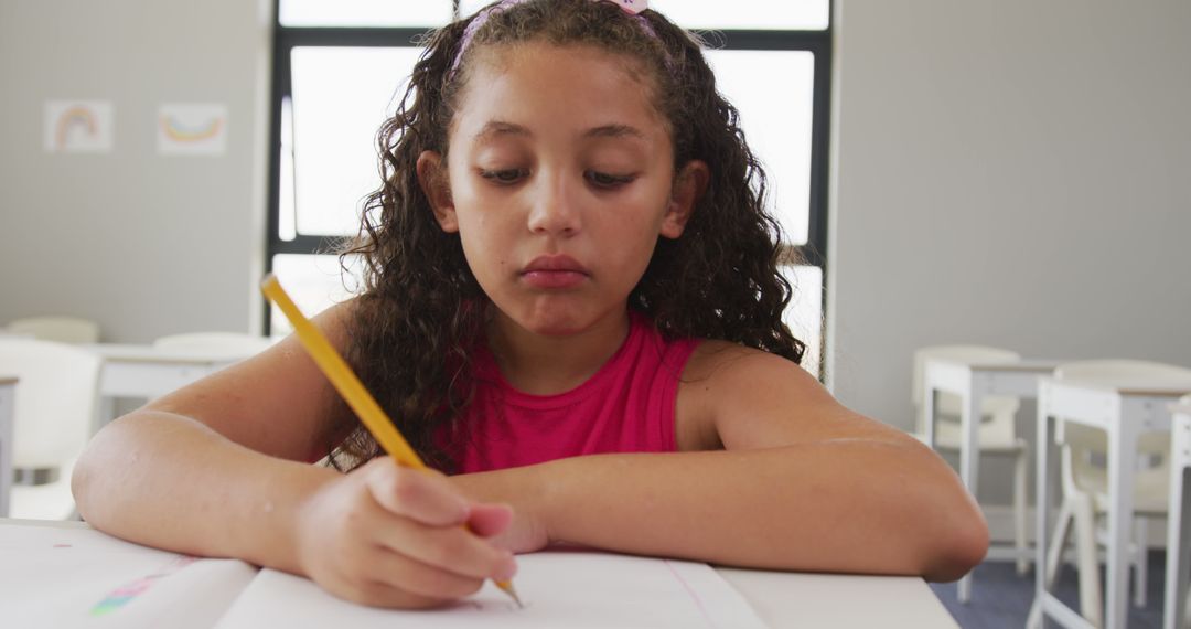 Focused Multiracial Girl Writing at School Desk - Free Images, Stock Photos and Pictures on Pikwizard.com