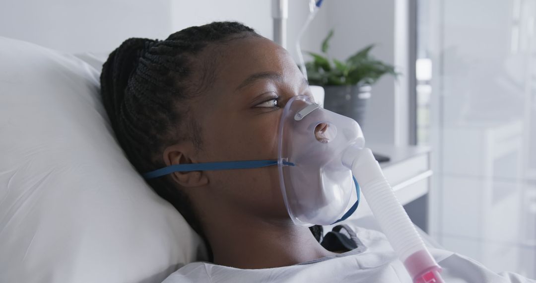 Young African American Woman Wearing Oxygen Mask in Hospital Bed - Free Images, Stock Photos and Pictures on Pikwizard.com