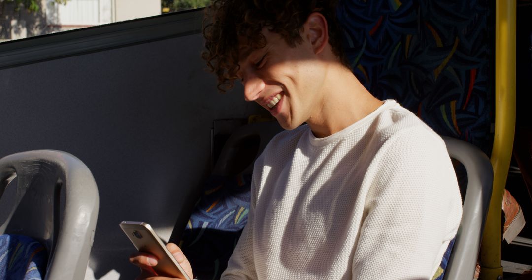 Smiling Young Man Texting on Mobile Phone while Sitting on Bus - Free Images, Stock Photos and Pictures on Pikwizard.com