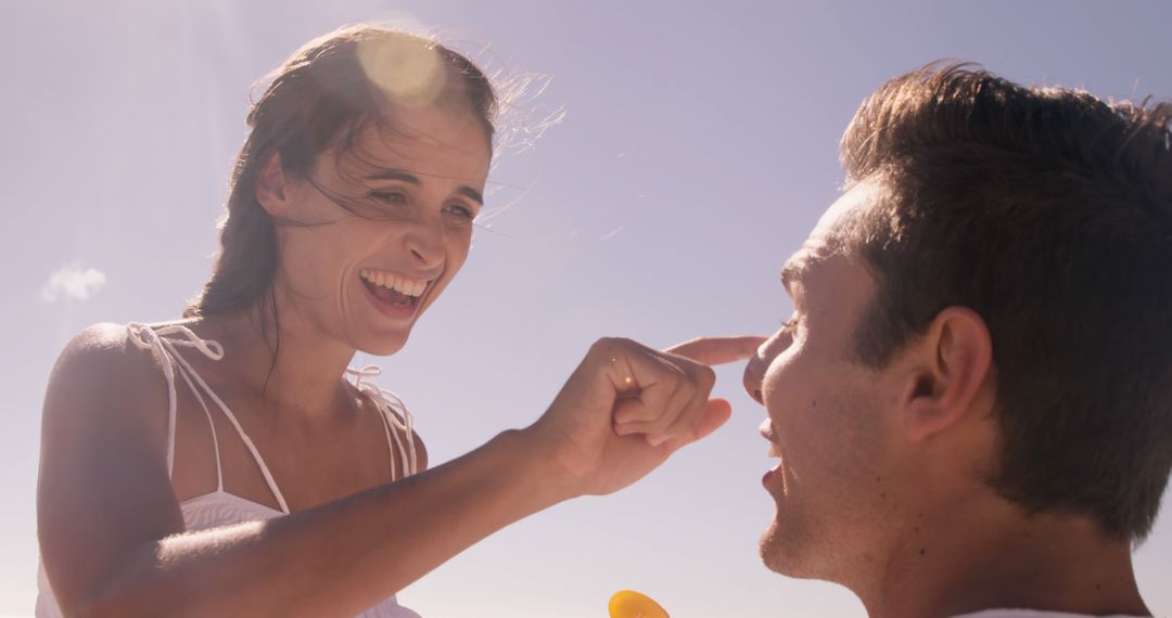 Happy Couple Applying Sunscreen on Beach - Free Images, Stock Photos and Pictures on Pikwizard.com