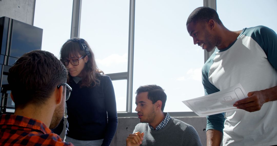 Diverse Team Collaborating on Project in Bright Office Space