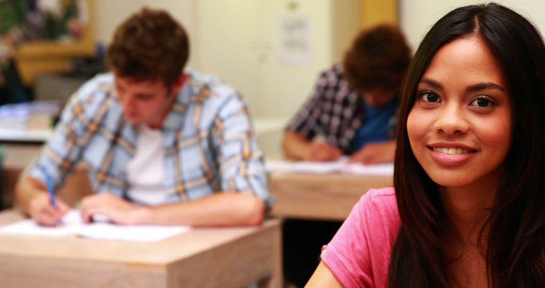 Smiling Female Student in Classroom During Exam - Free Images, Stock Photos and Pictures on Pikwizard.com