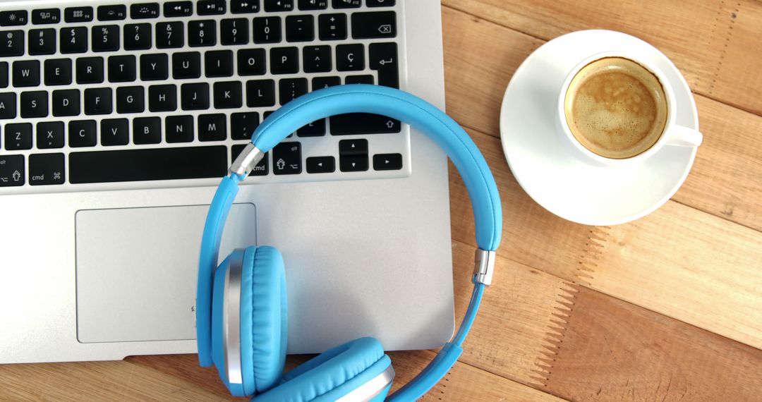 Workspace with Blue Headphones, Laptop, and Coffee Cup on Wooden Desk - Free Images, Stock Photos and Pictures on Pikwizard.com