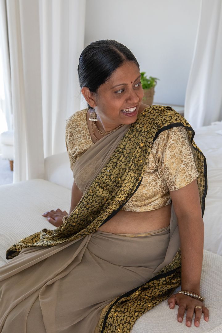 Elegant Mature Indian Woman in Traditional Saree Sitting in Bedroom