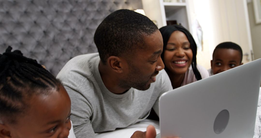 African American Family Enjoying Quality Time Watching Laptop on Bed - Free Images, Stock Photos and Pictures on Pikwizard.com