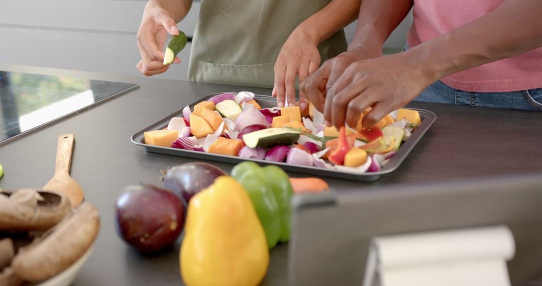 Couple Preparing Fresh Vegetables on Baking Tray in Kitchen
