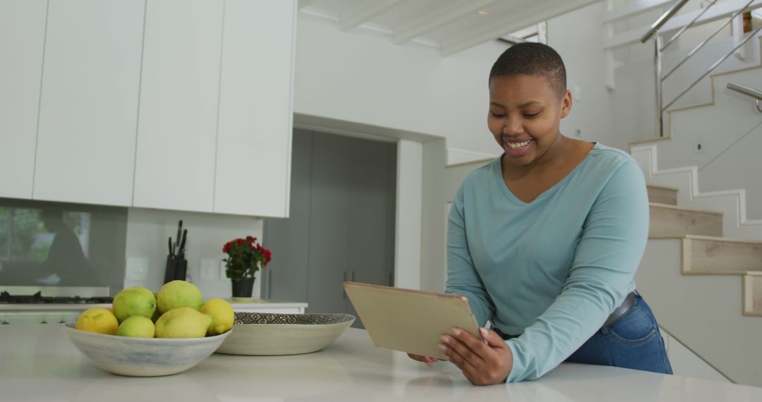 Smiling Young Black Woman Using Tablet in Modern Kitchen - Free Images, Stock Photos and Pictures on Pikwizard.com