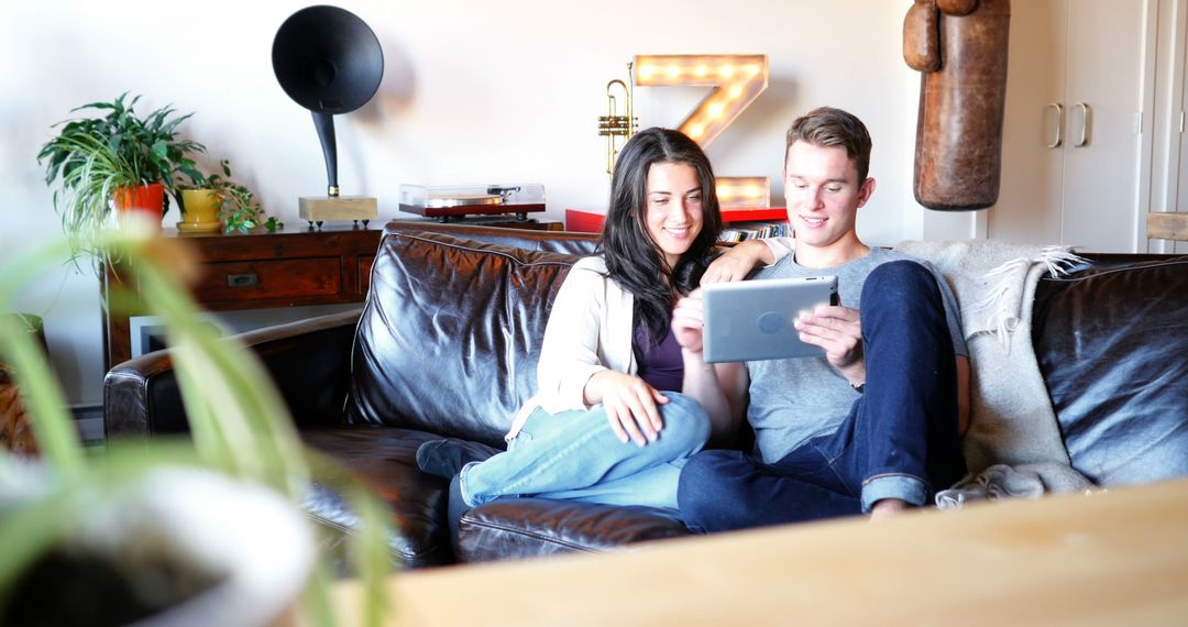 Couple Relaxing on Couch Enjoying Digital Tablet