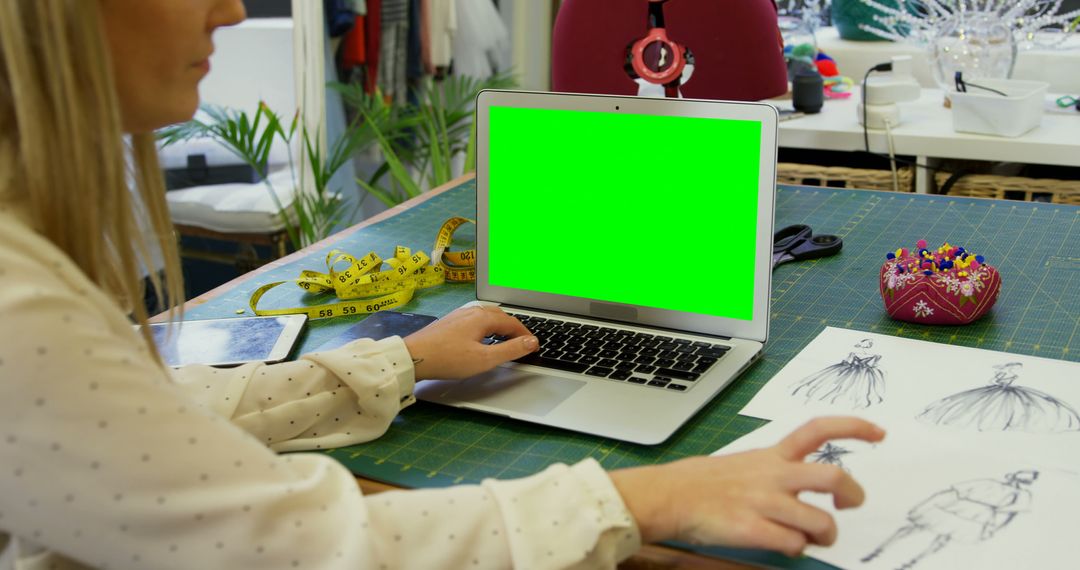 Fashion Designer Utilizing Laptop Green Screen in Creative Workspace - Free Images, Stock Photos and Pictures on Pikwizard.com