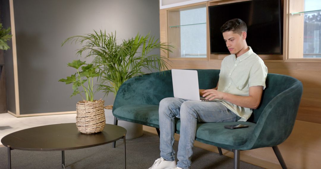 Businessman Multitasking with Laptop in Modern Office Lounge
