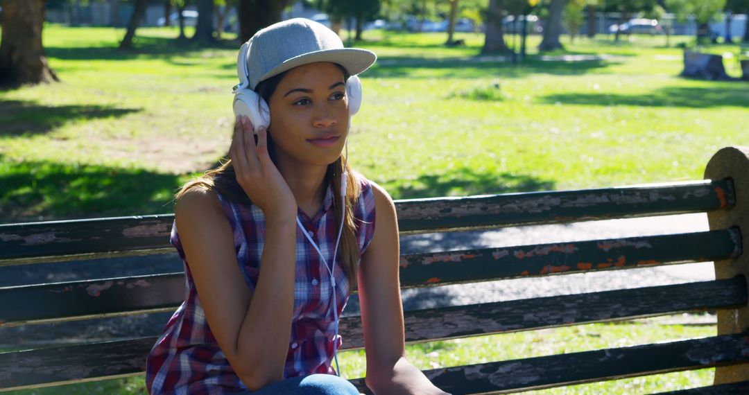 Young Woman Listening to Music on Bench in Park - Free Images, Stock Photos and Pictures on Pikwizard.com