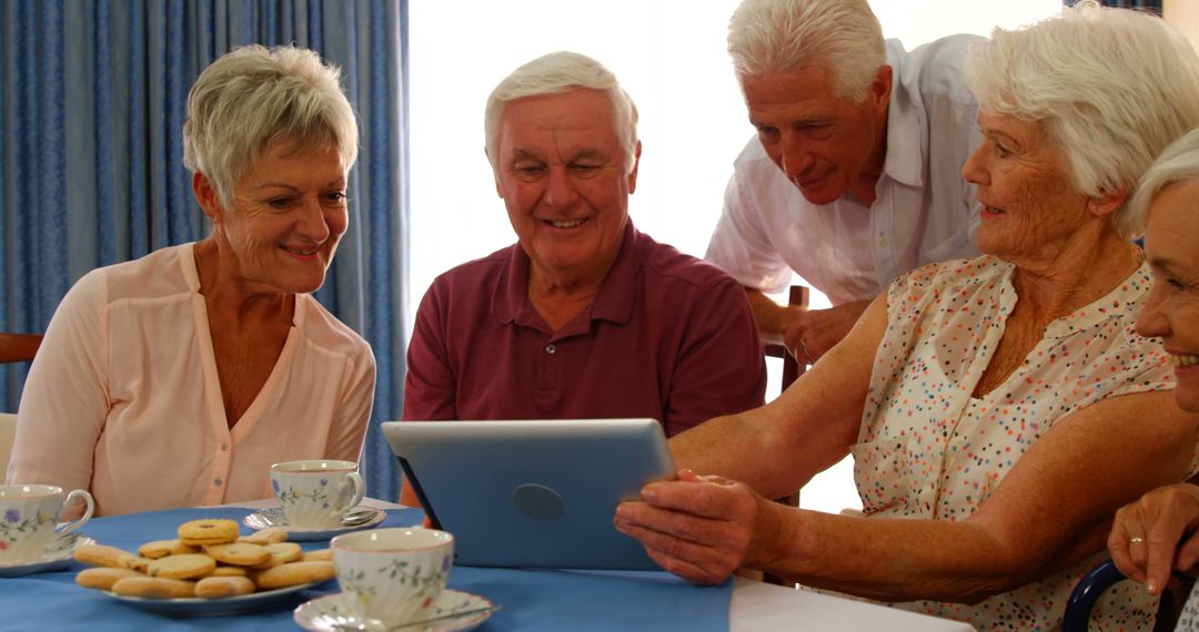 Group of Senior Friends Enjoying While Watching Tablet at Home - Free Images, Stock Photos and Pictures on Pikwizard.com