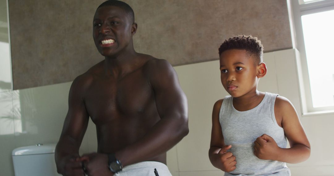 Image of happy african american father and son showing muscles in mirror - Free Images, Stock Photos and Pictures on Pikwizard.com