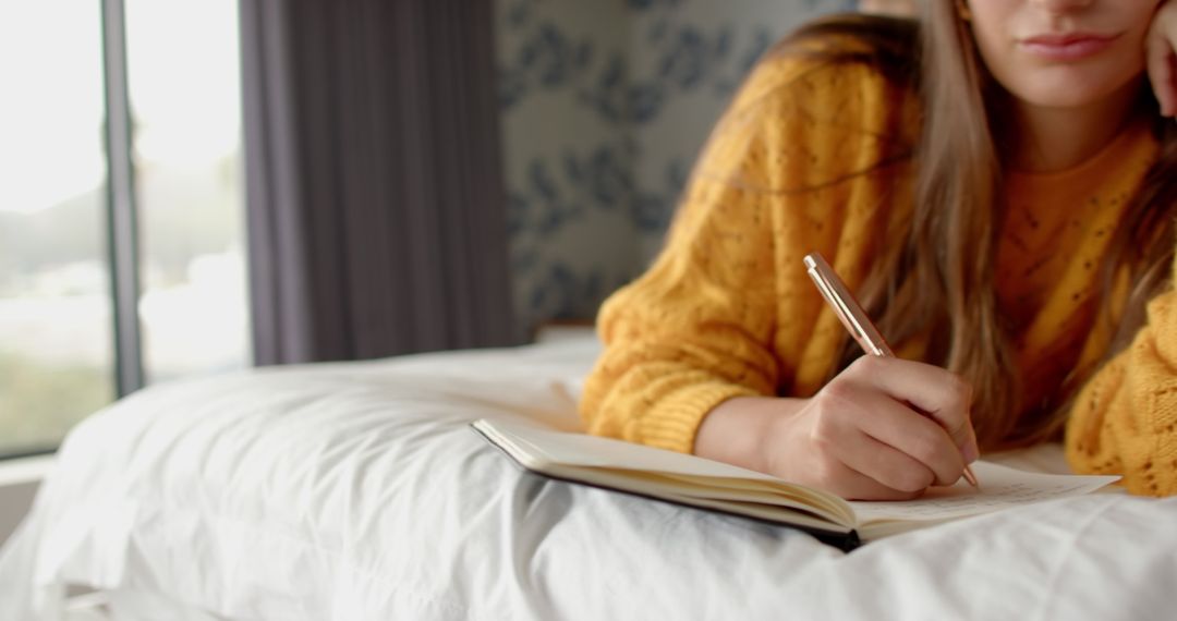 Woman Relaxing and Writing in Notebook by Window