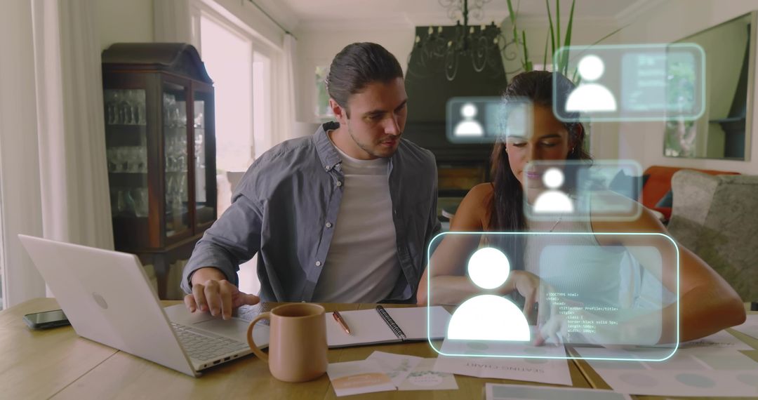 Young Couple Collaborating at Home Desk Reviewing Documents with Holographic UI and Laptop